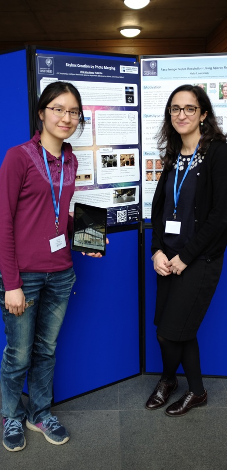 Two researchers pose in front of a poster board at Oxford's Department of Engineering Sciences