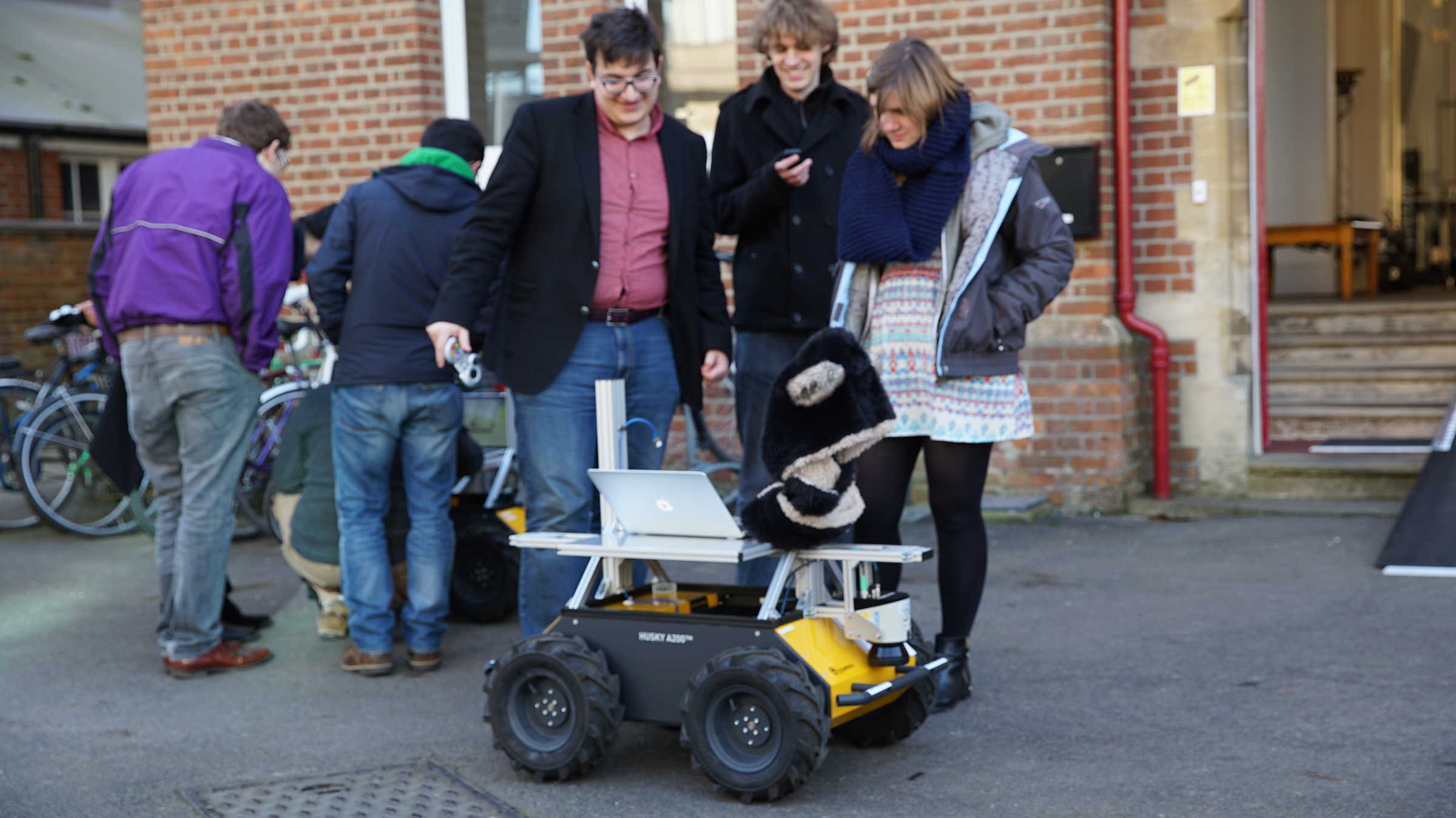 researchers crowd around a robot outside at Oxford's Department of Engineering Sciences