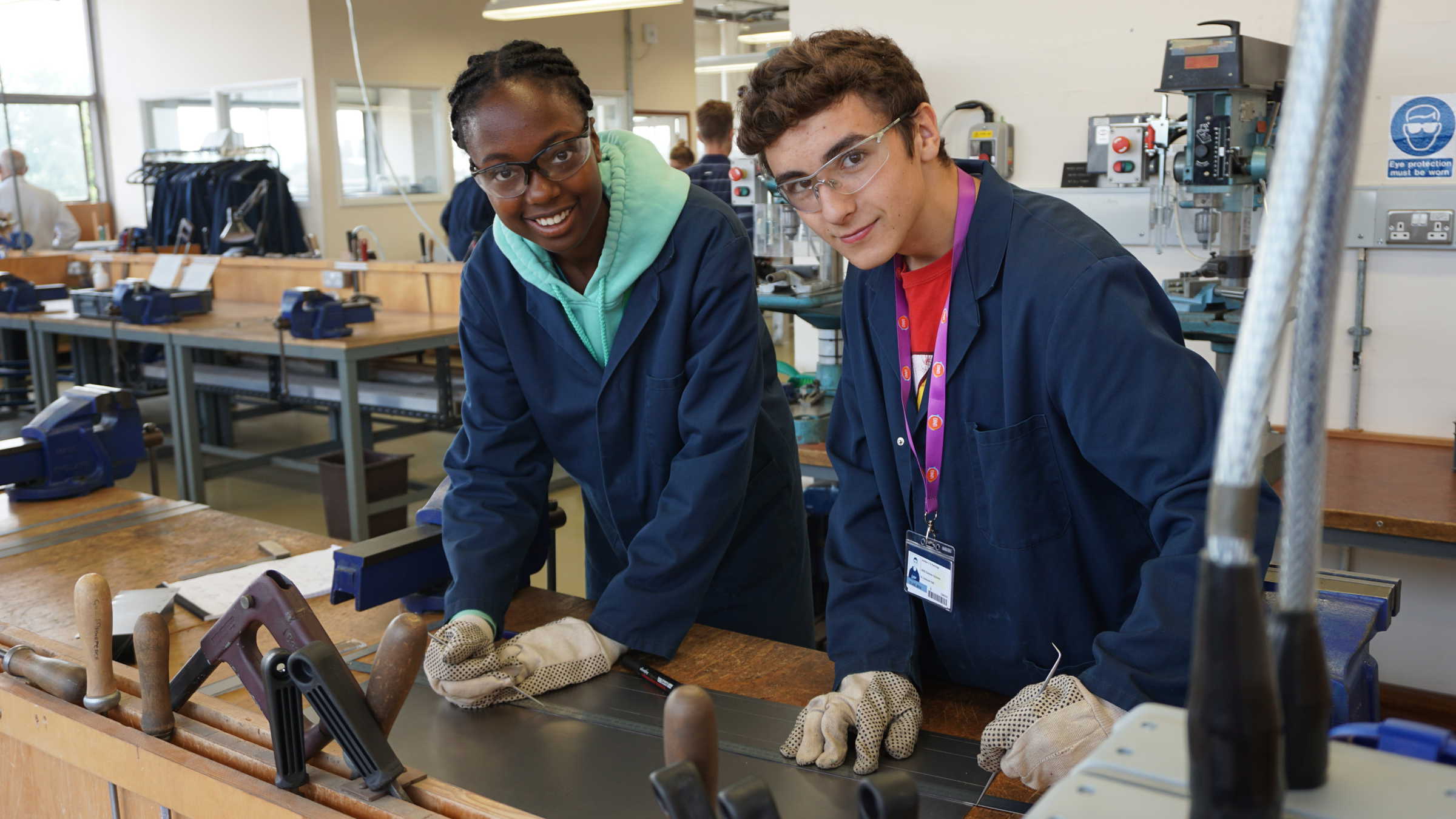 Two students wearing safety gear in laboratory workshop