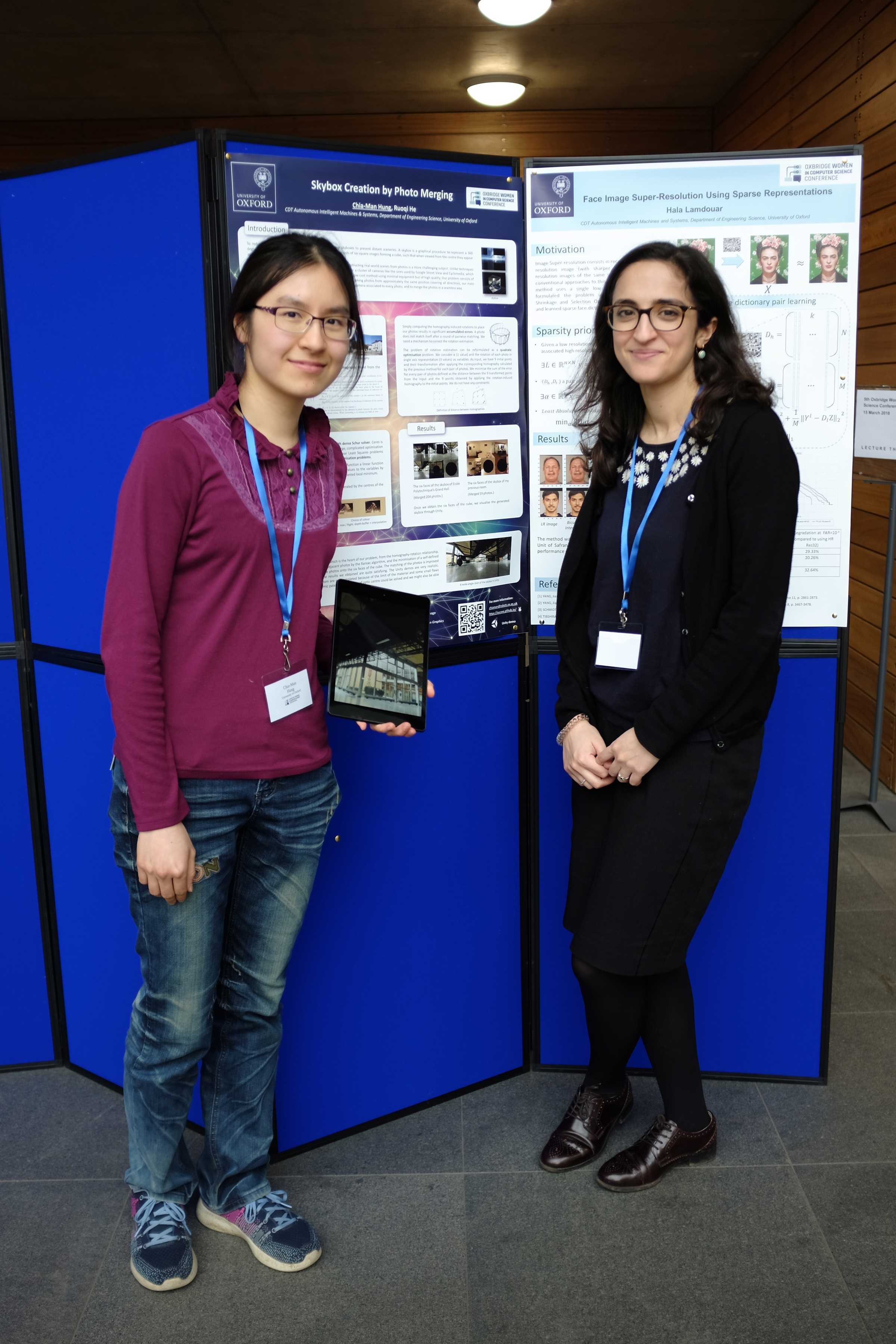 Two researchers pose in front of a poster board at Oxford's Department of Engineering Sciences